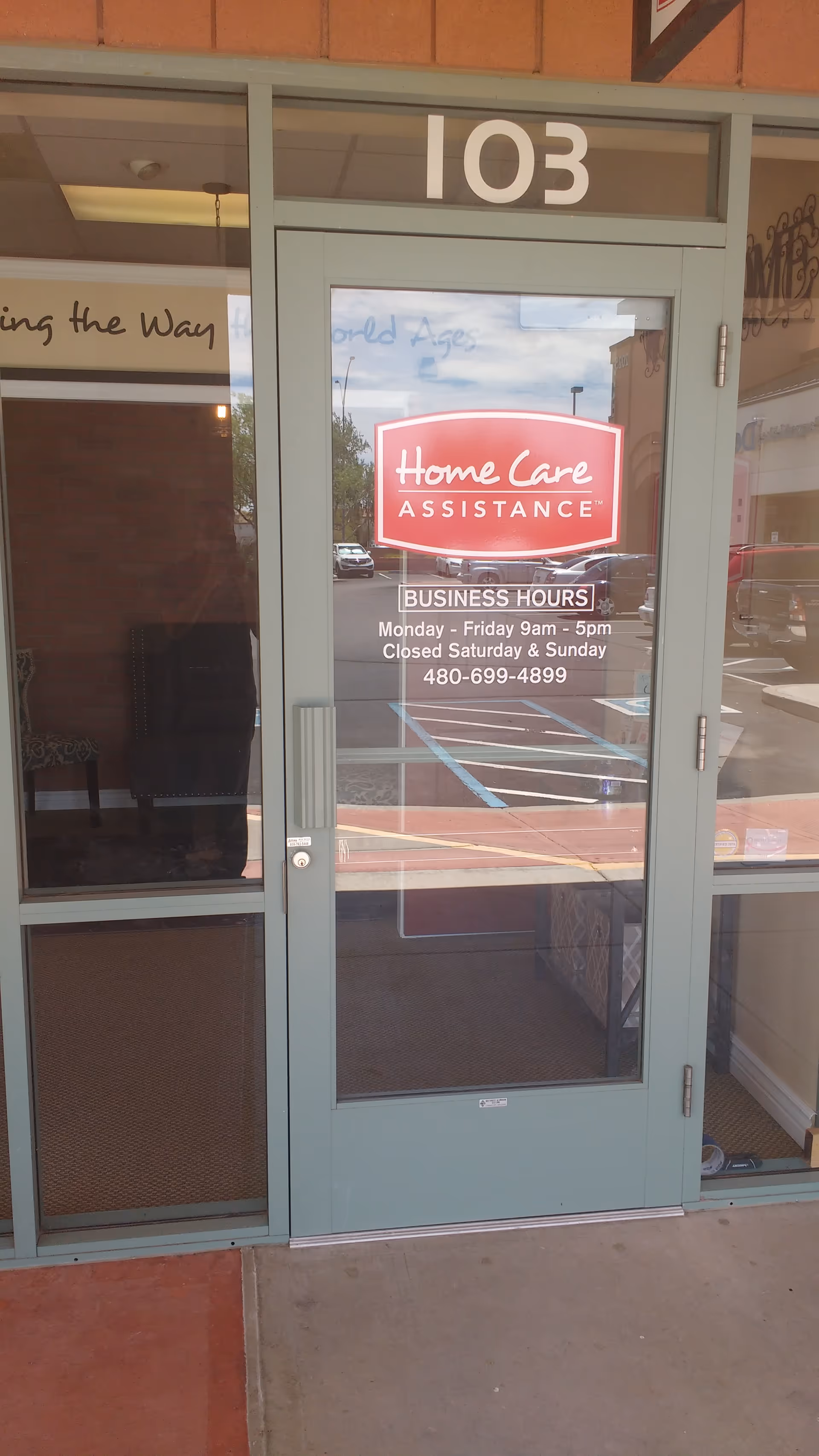 Glass entrance door displaying Home Care Assistance sign and business hours.