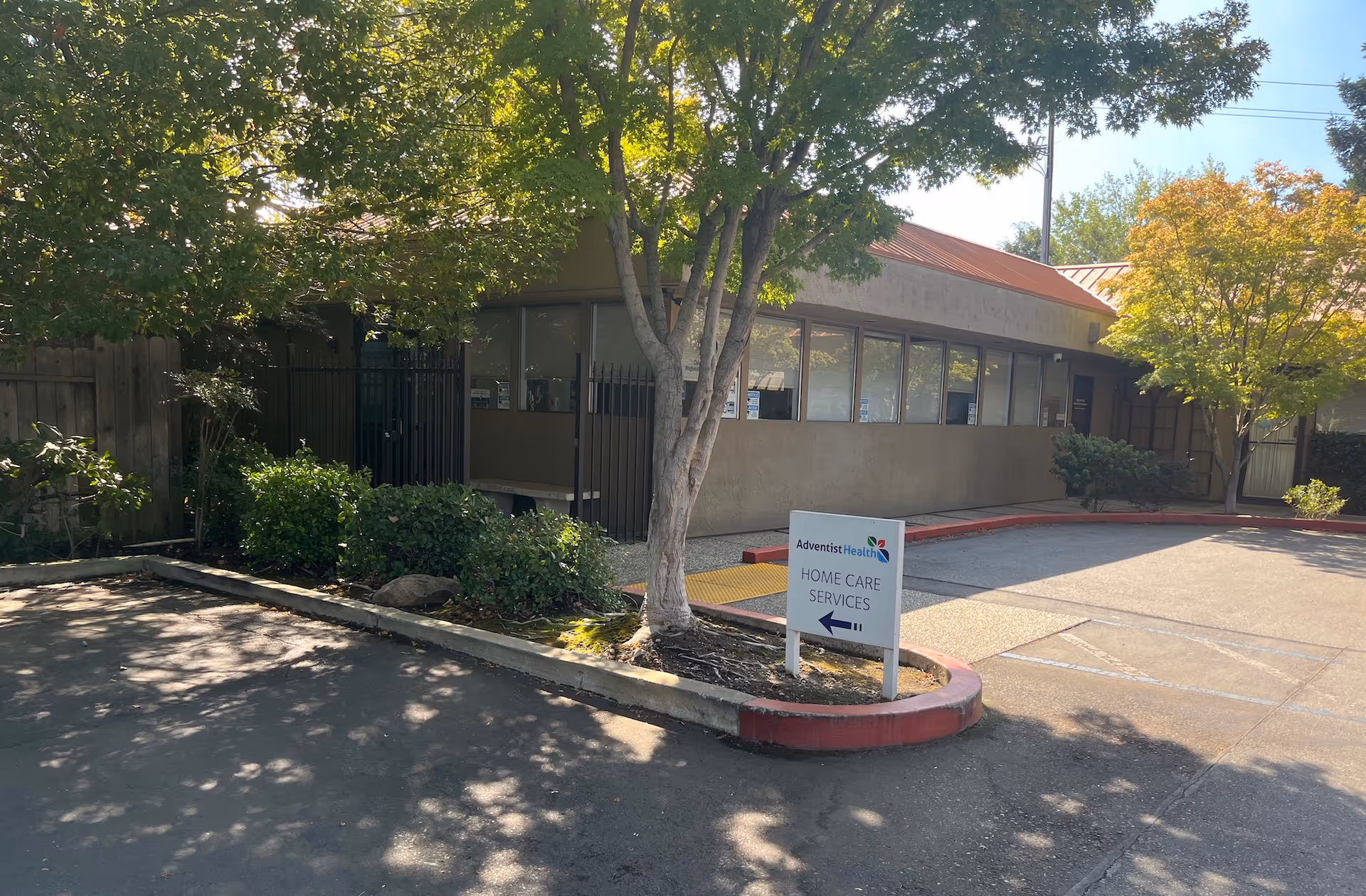 Exterior view of Adventist Health Home Care Services with sign, driveway, and trees.