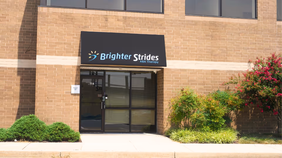 Brick facility exterior with Brighter Strides ABA Therapy sign above glass entrance doors.