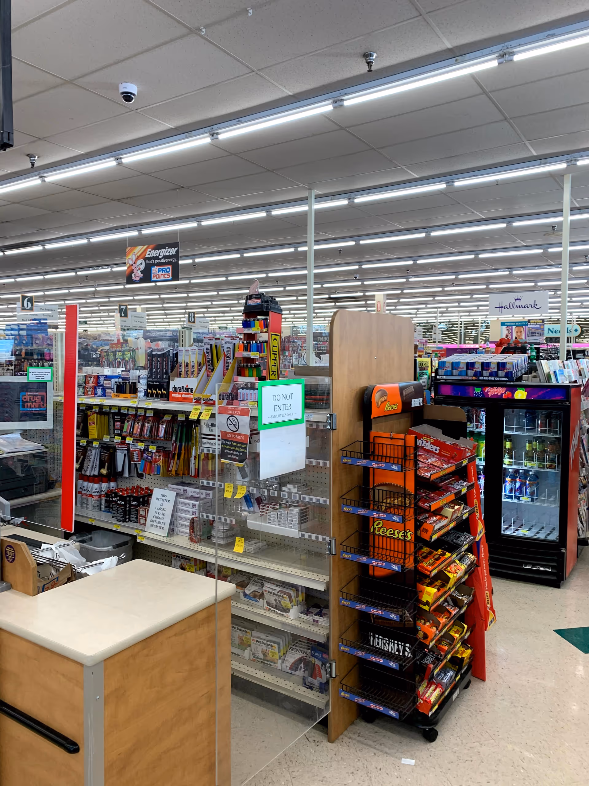 Interior of Discount Drug Mart showing checkout counter, aisles, and snack shelves.