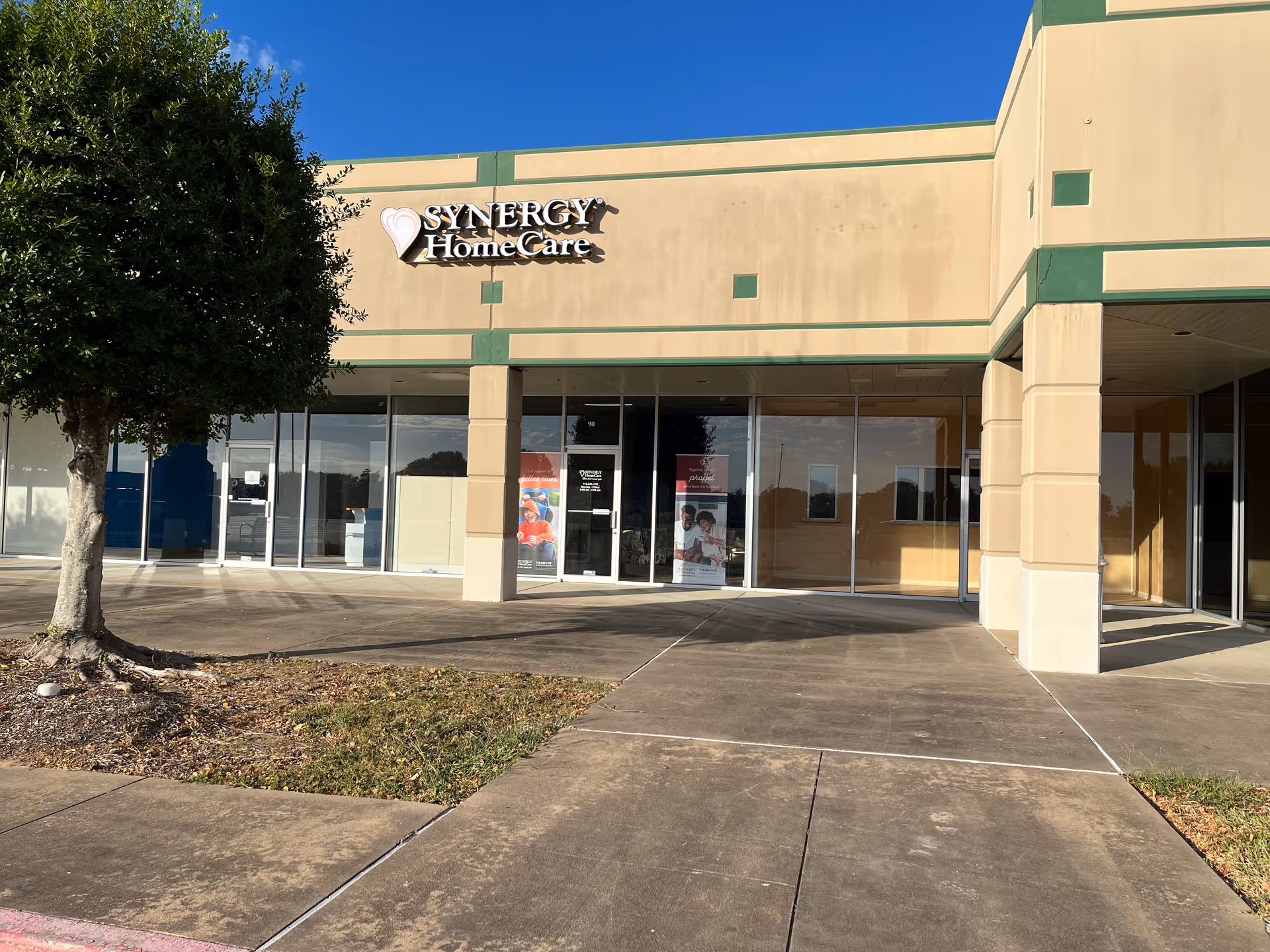 Front view of a SYNERGY HomeCare facility with glass doors and sign