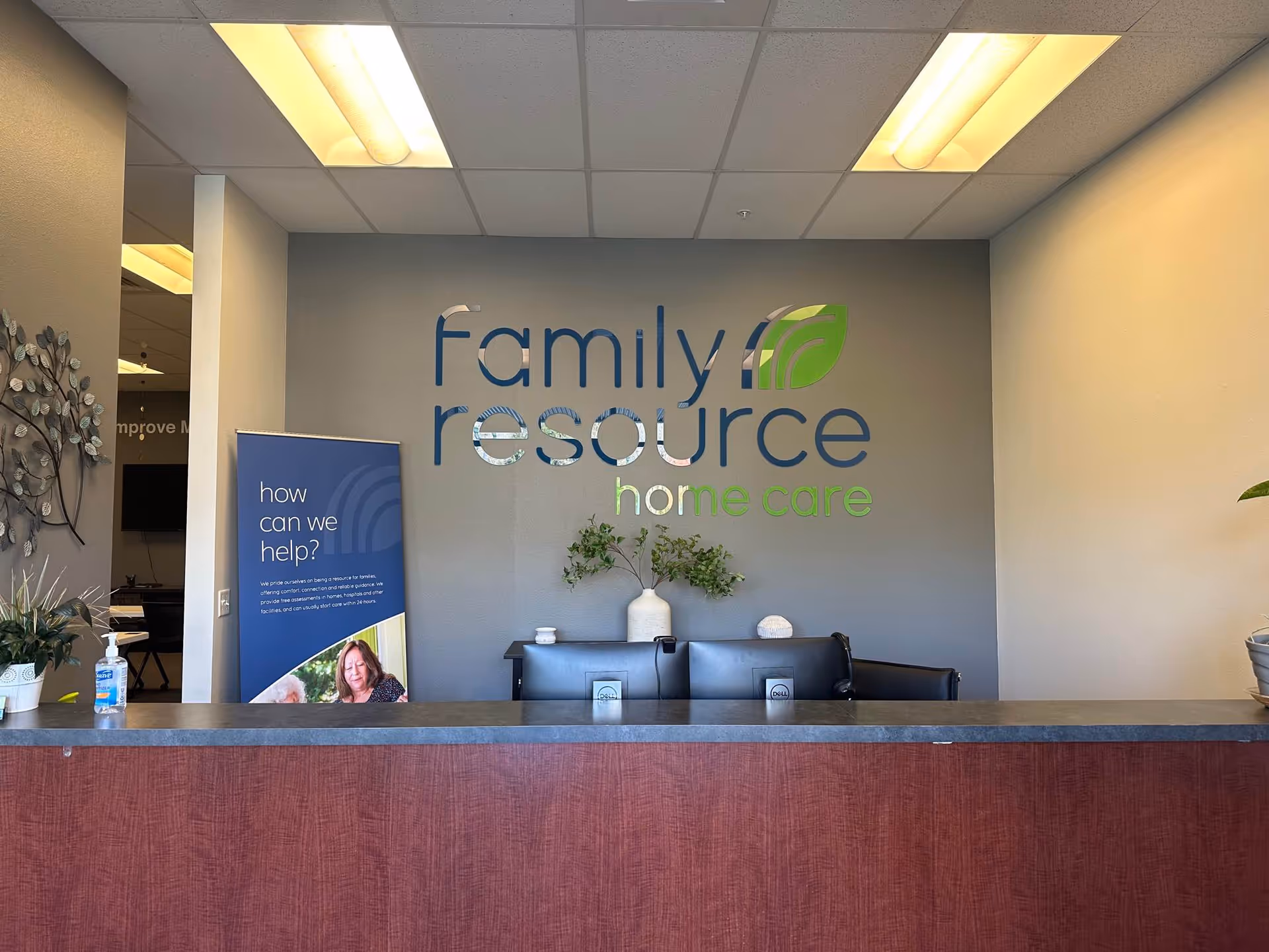 Reception desk in a Family Resource Home Care lobby with a wall logo