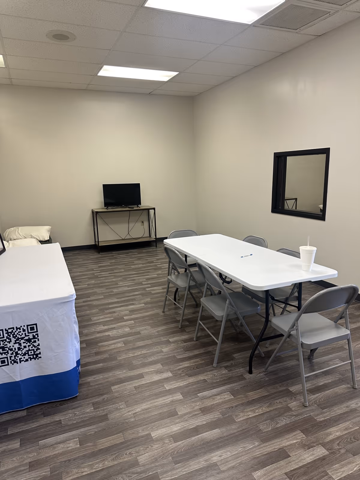 Senior living facility room with folding table, chairs, TV, and a bed.