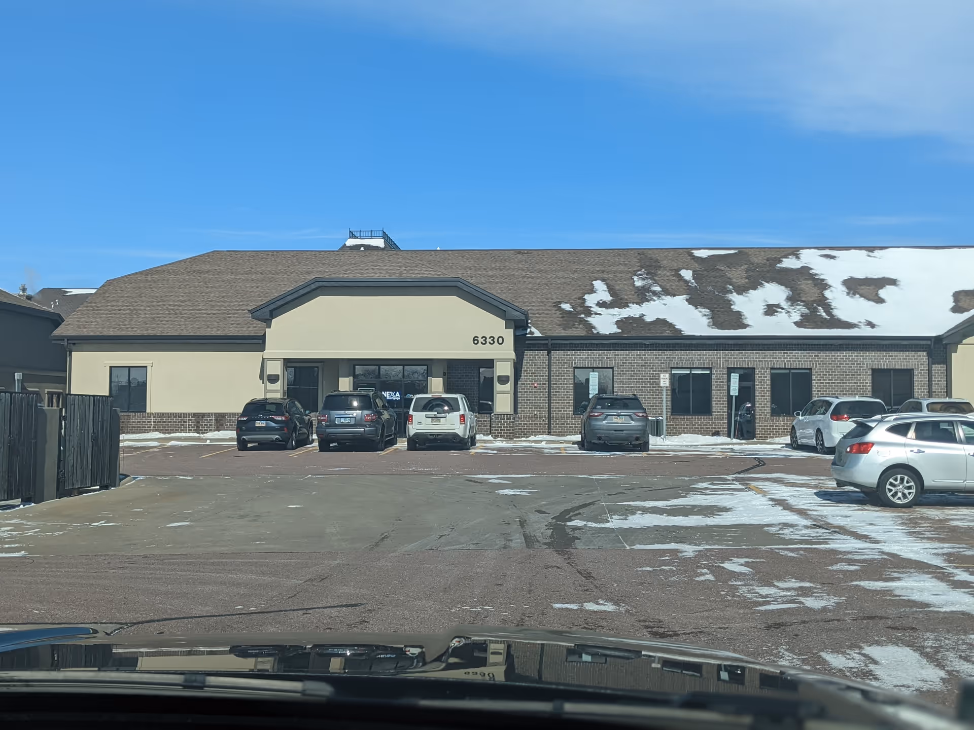 Front exterior view of St. Croix Hospice building with several parked cars.