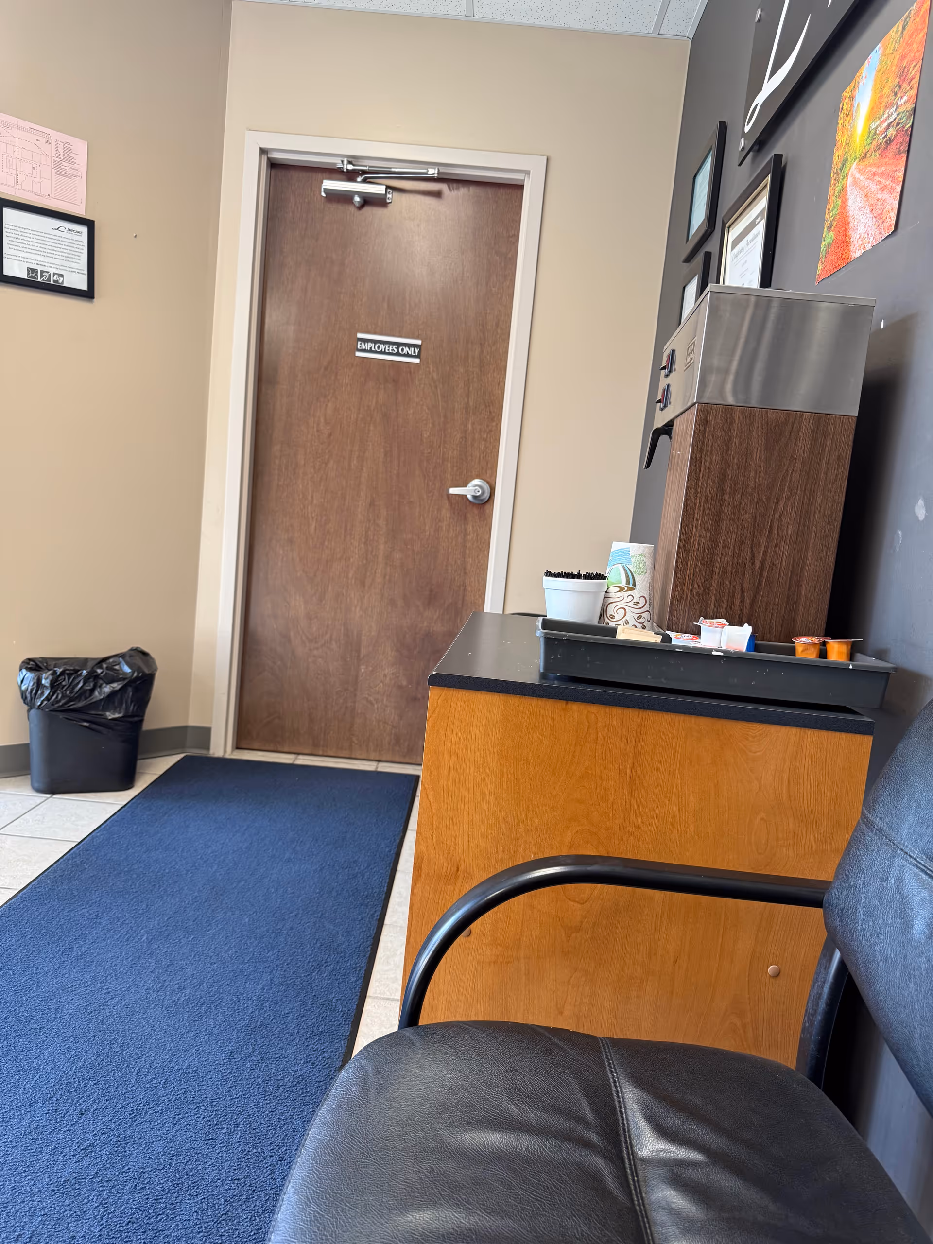 Interior hallway of a LINCARE facility with a door labeled Employees Only and a reception counter.