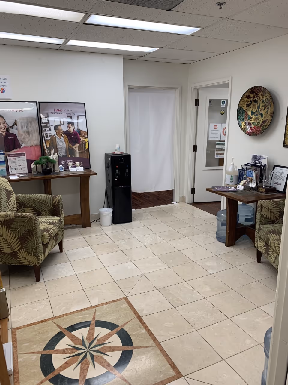 Interior waiting area with chairs, brochures, a water cooler, and a decorative tiled floor.