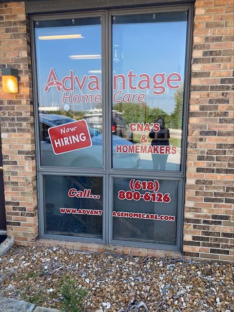 Glass doors and windows with Advantage Home Care signage on a brick exterior storefront.