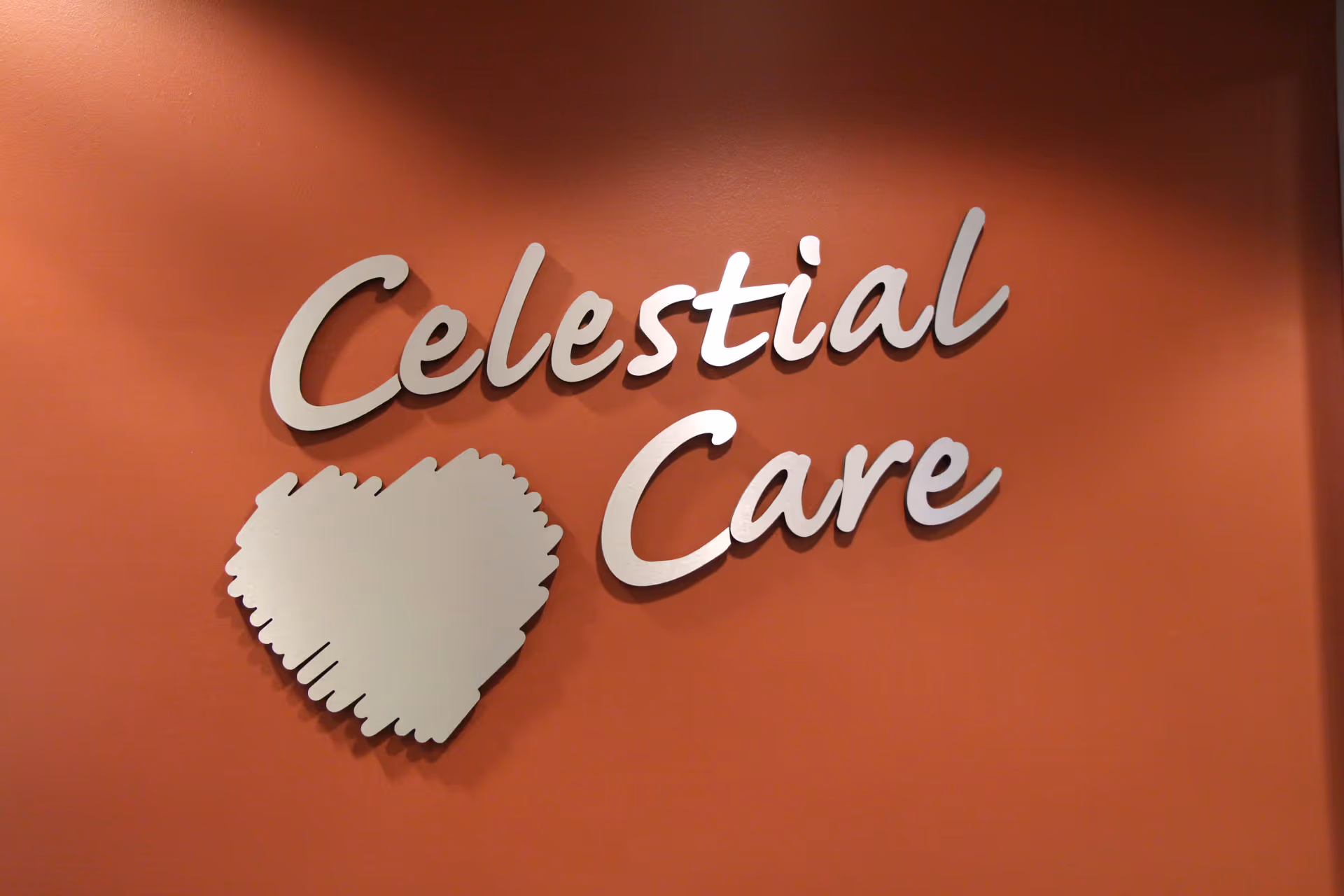 Red wall displays Celestial Care sign with a white decorative emblem.