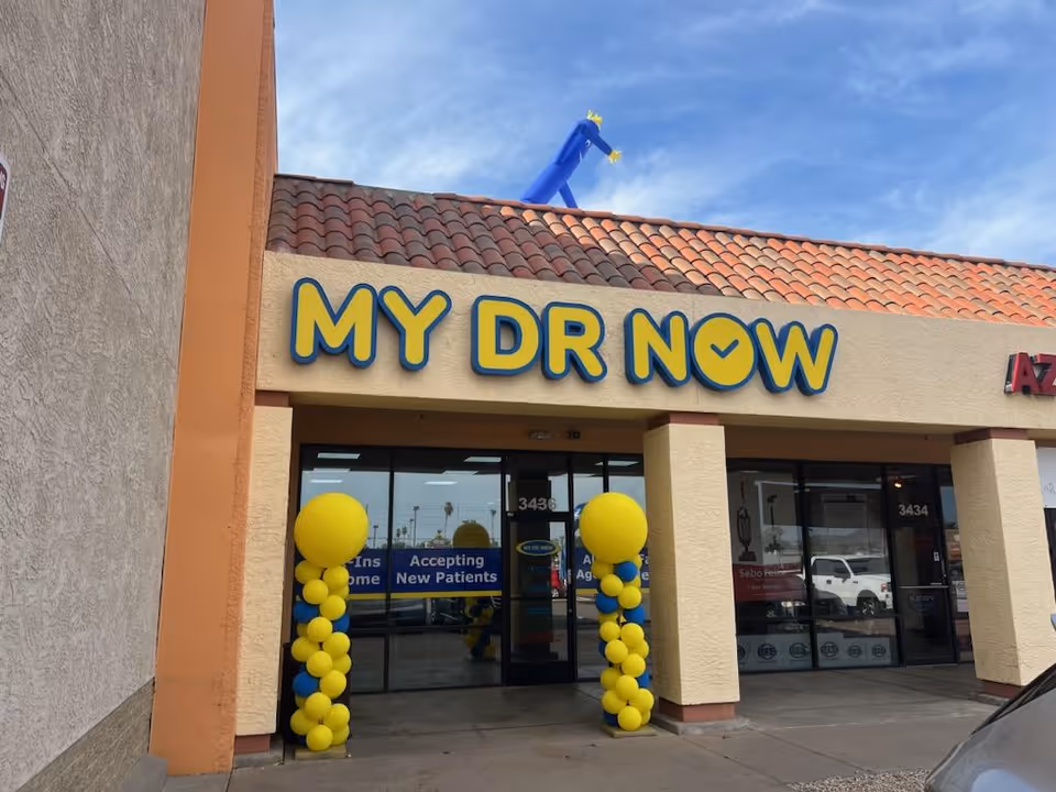 Exterior view of MY DR NOW storefront with blue-yellow sign and balloons.
