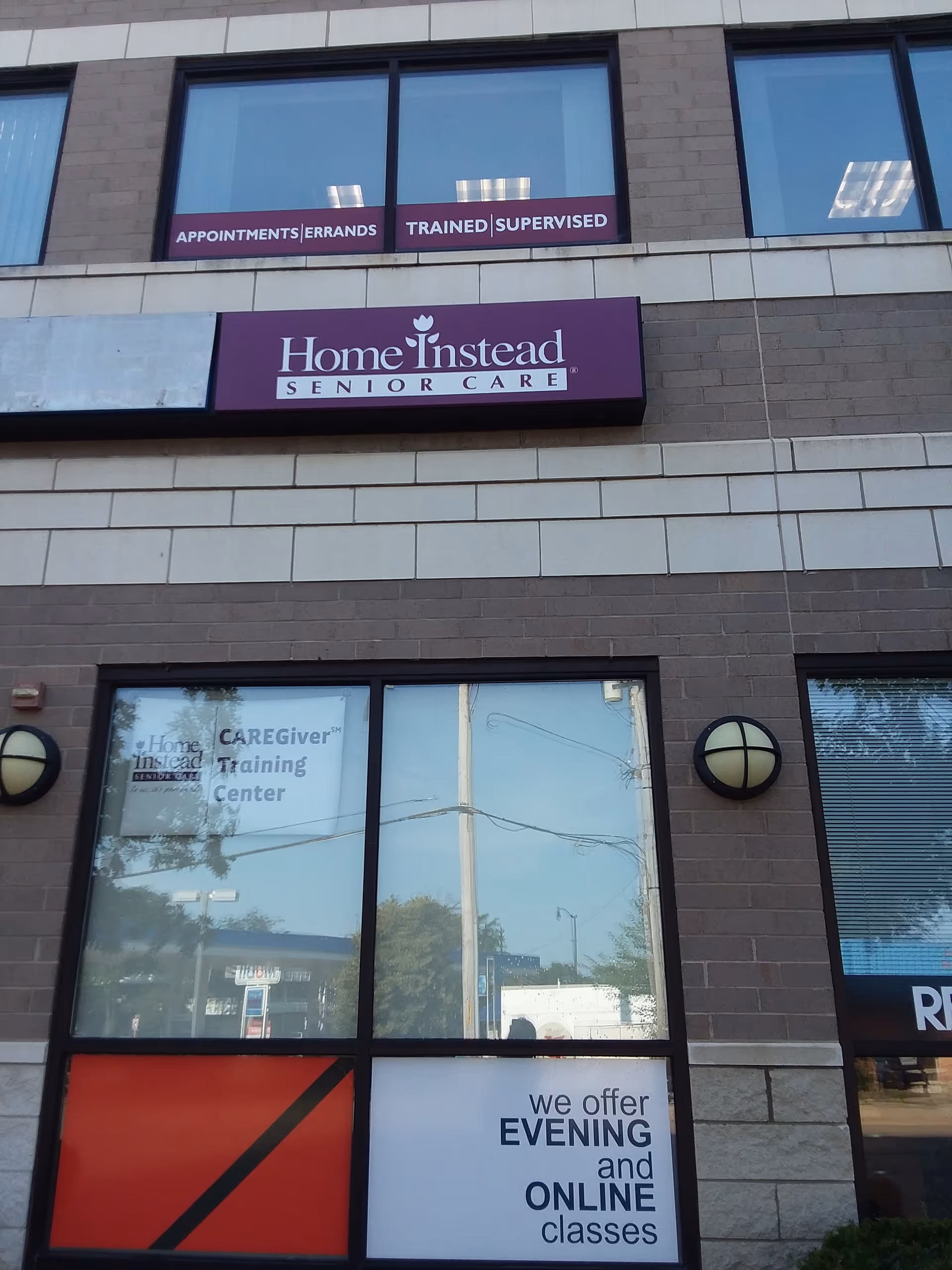 Exterior facade of a Home Instead Senior Care building with signs and windows.