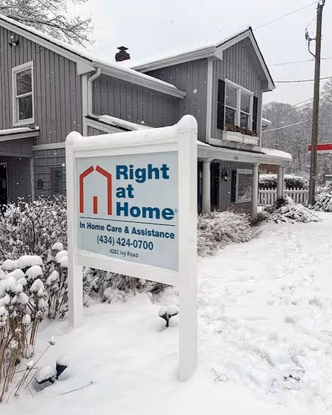Winter exterior view of a Right at Home building with a snow-covered sign.