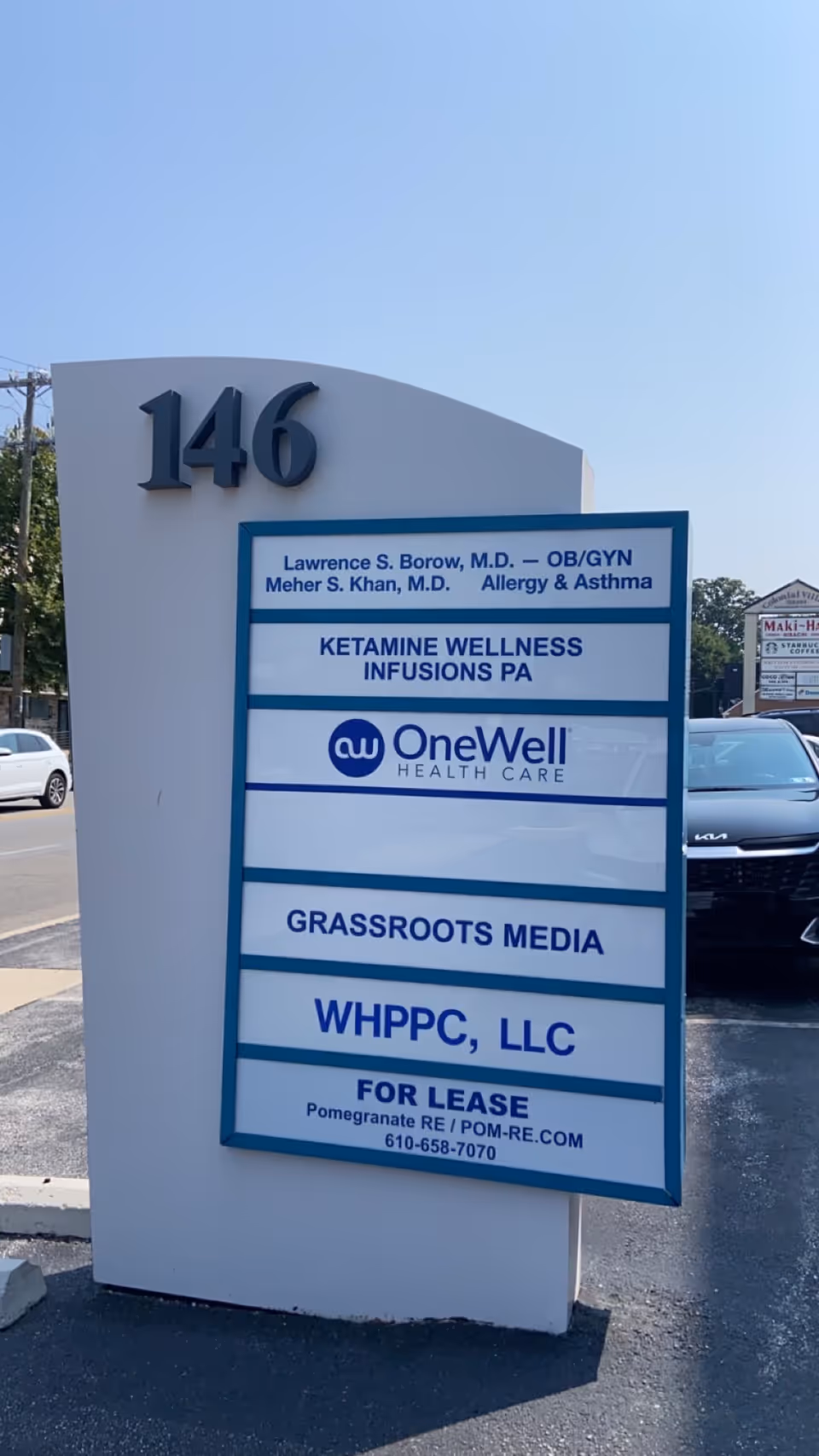 Exterior building sign with the number 146 and a blue-framed directory board.