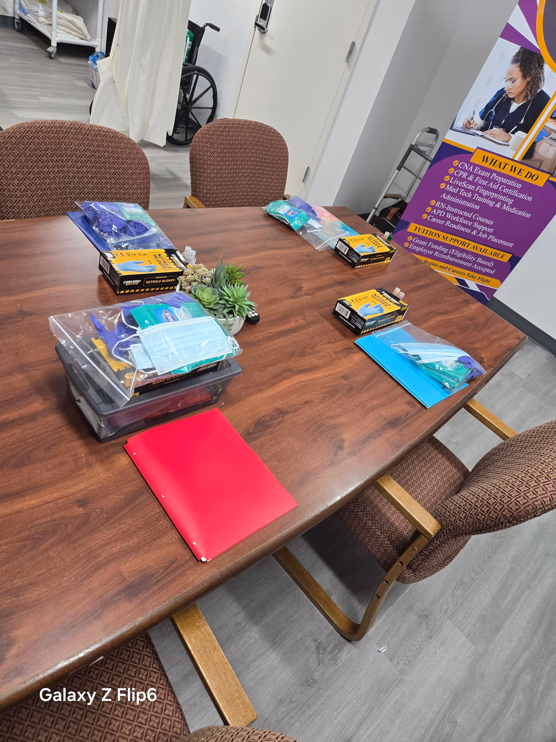 A conference table with medical supply kits and a purple promotional banner nearby.