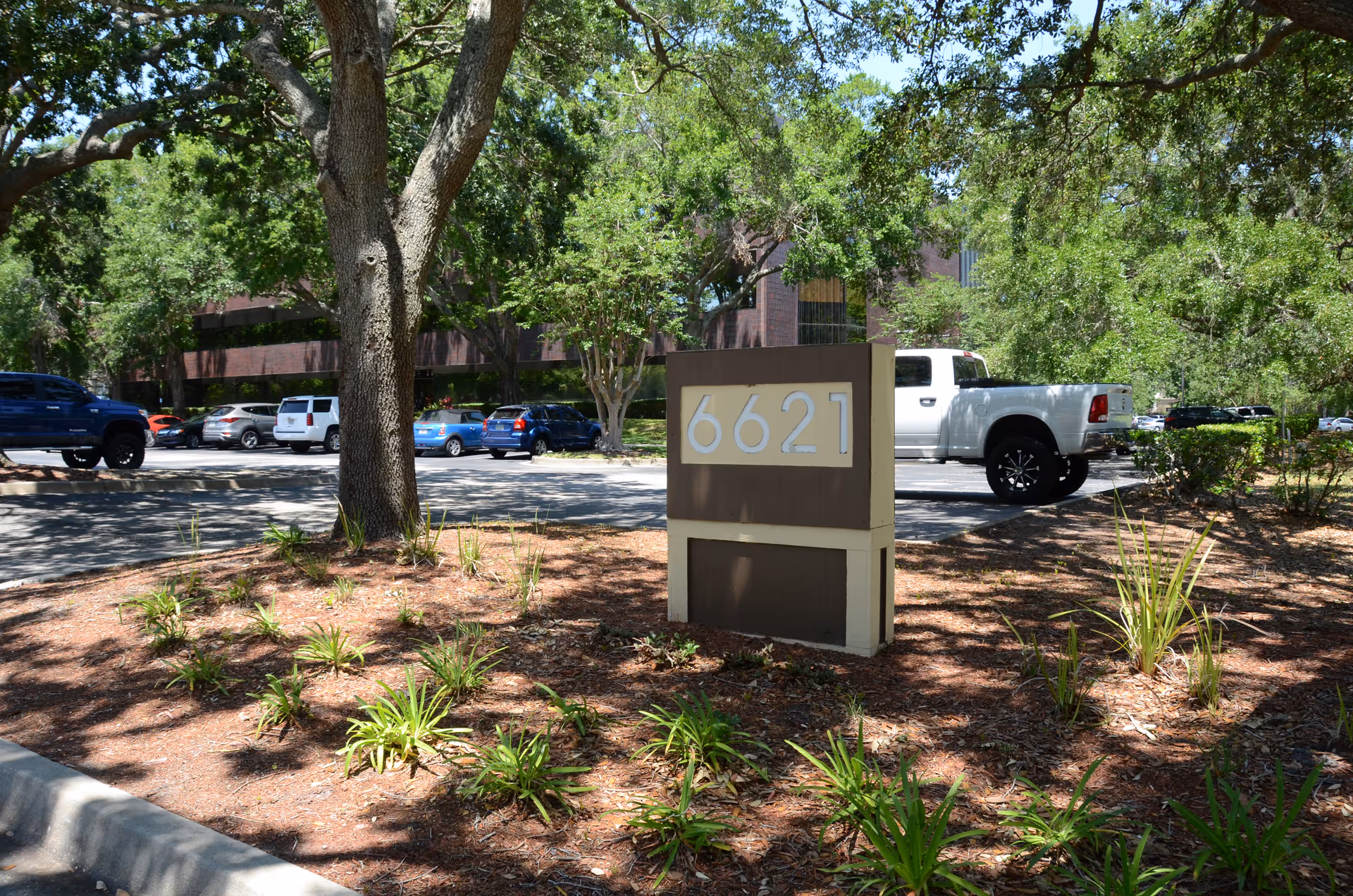 Exterior view of a facility with a parking lot, trees, and a large 6621 sign.