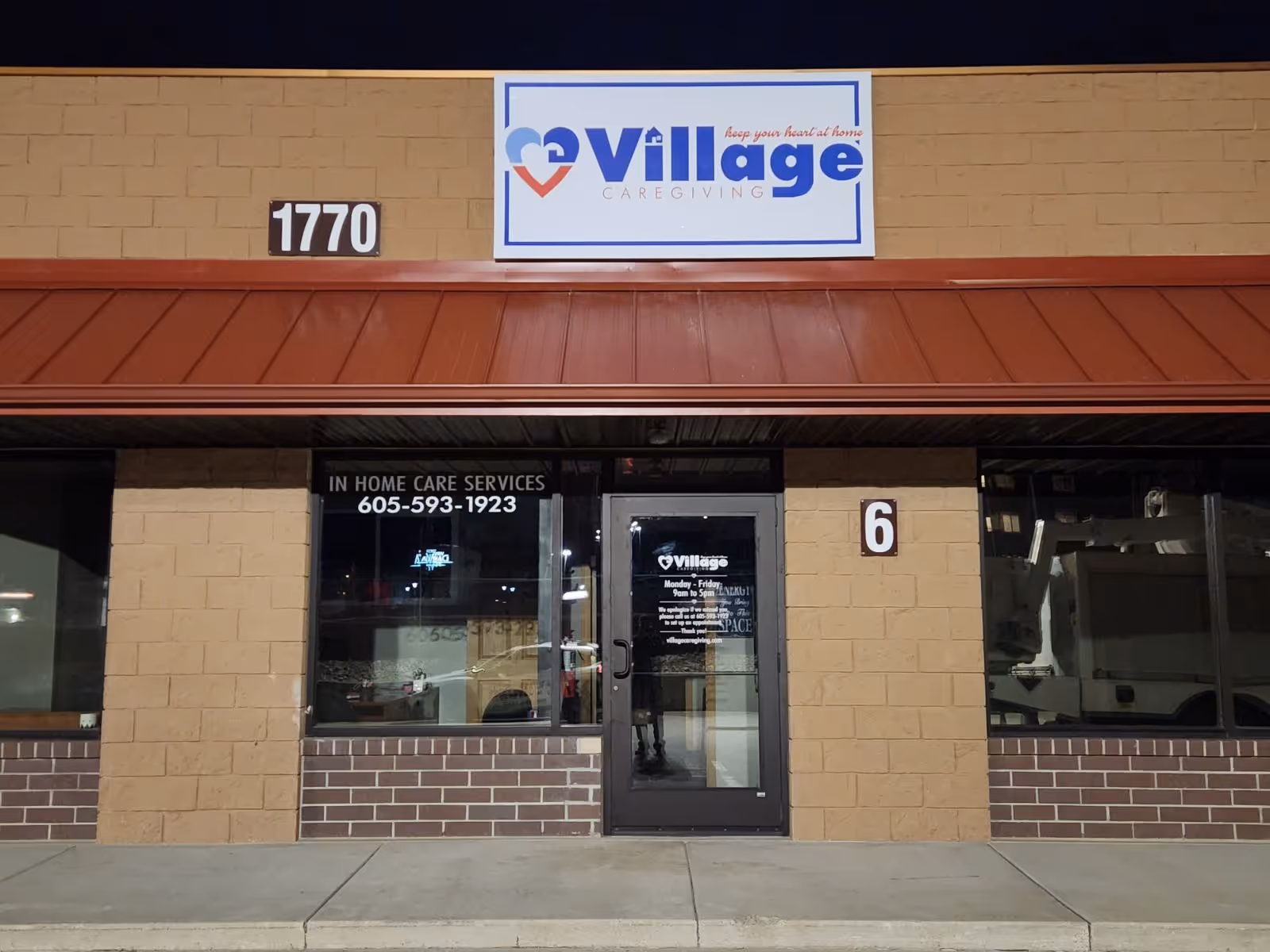 Exterior storefront of Village Caregiving with sign, windows, door, and street number 1770.