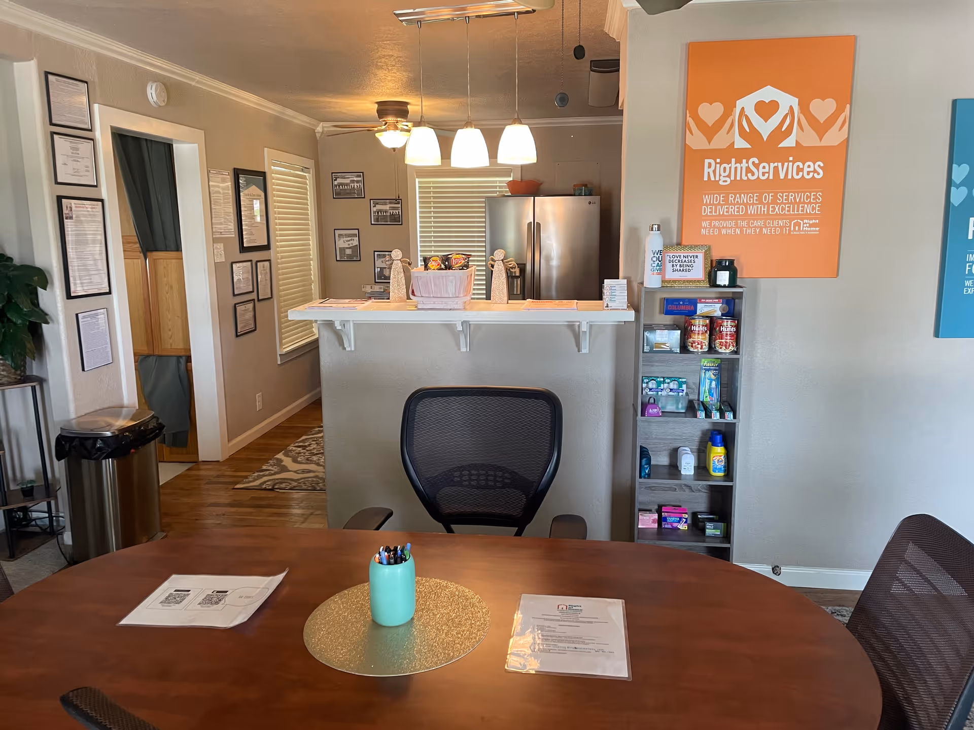 Reception area of Right at Home with a counter, round table, and shelving.
