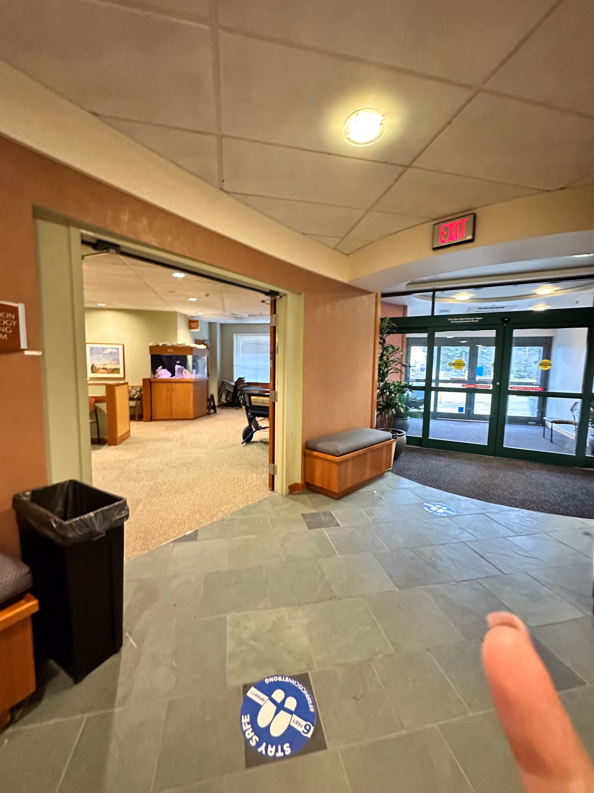 Interior view of a hospital lobby with seating and glass entry doors.