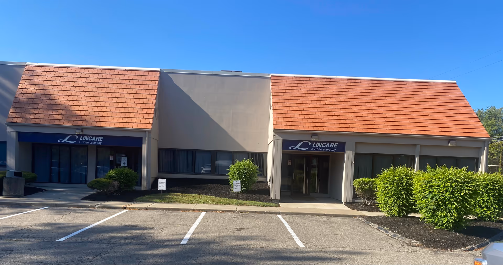 Exterior view of a LinCare building with a red-tiled roof and storefront entrances.