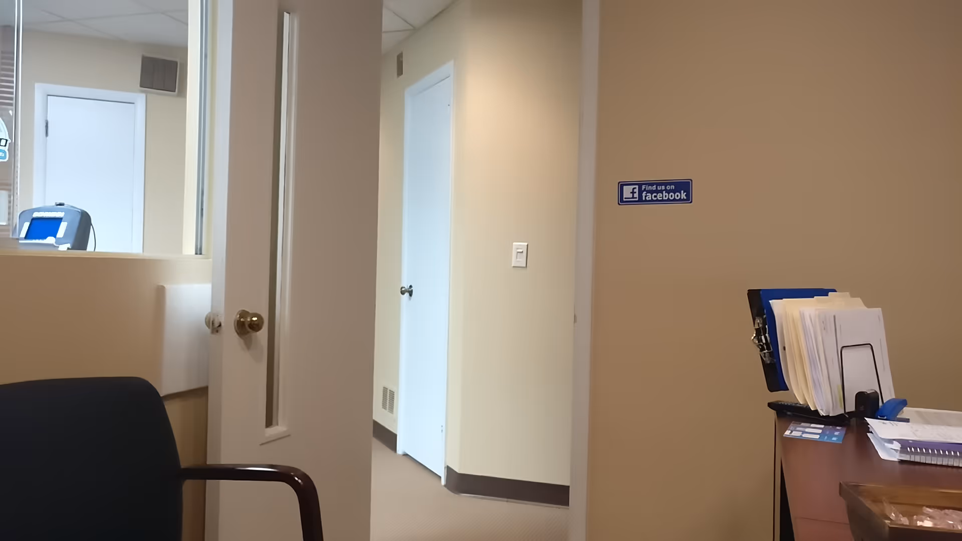 Interior reception area at Richmond Physical Therapy with desk, paperwork, and Facebook sign.