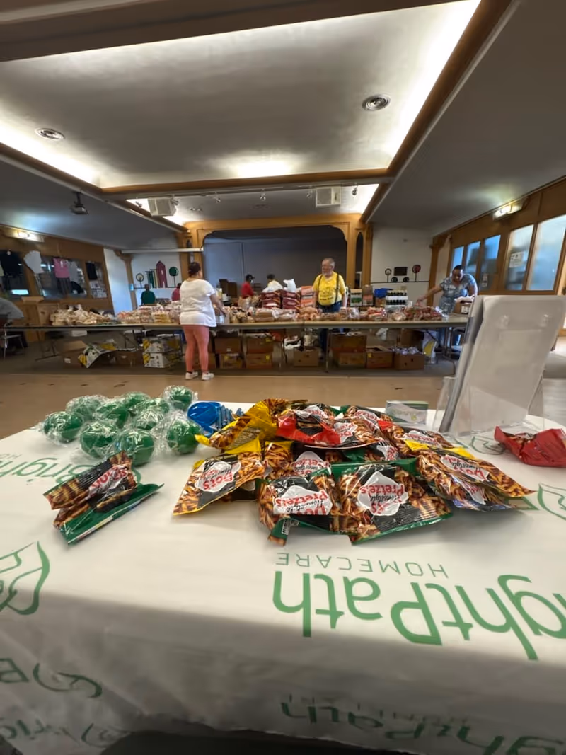 A dining area in a senior home with snacks displayed on a long table.