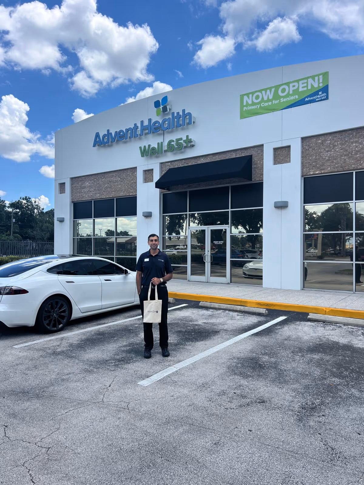 A man stands in a parking lot outside an AdventHealth Well 65+ facility.