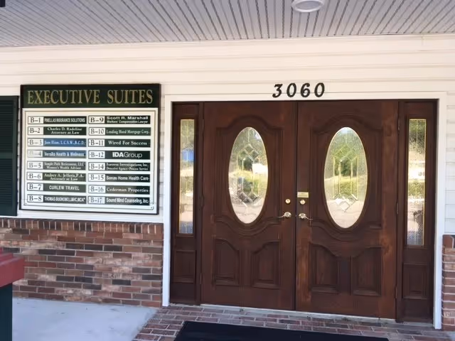 Executive Suites sign beside double wooden doors at building entrance 3060.