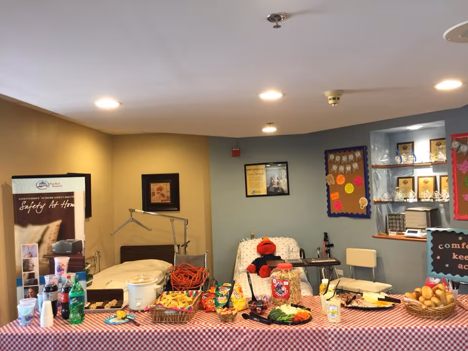 Communal care area with a snack table, bed, and bulletin boards.