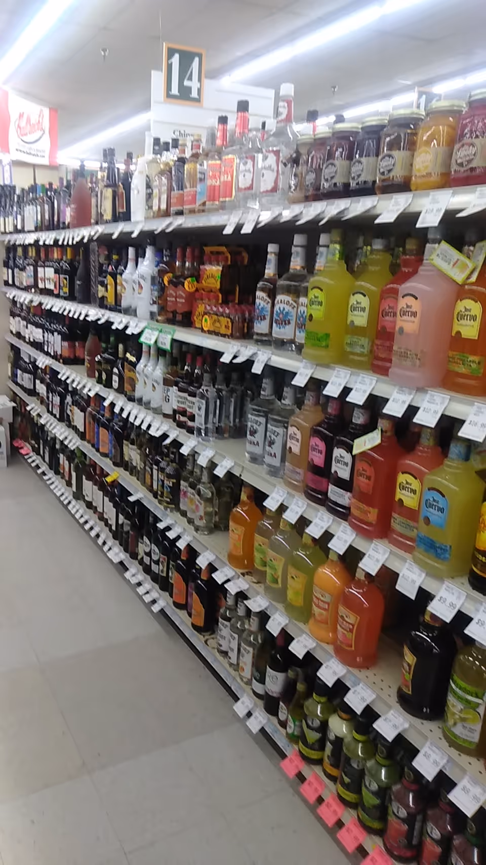Interior store aisle lined with shelves of bottled beverages.