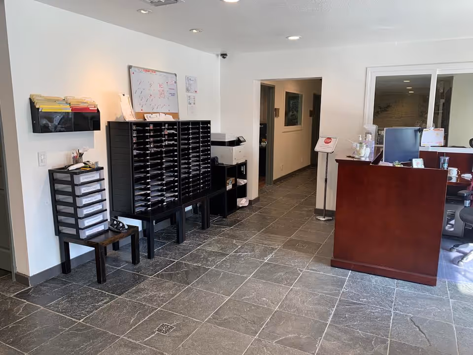 Interior lobby with a reception desk, mail shelves, and a hallway in a senior living facility.