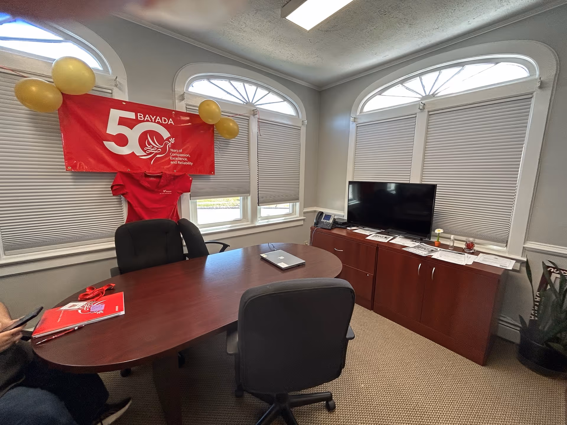 Office conference room with BAYADA banner, table, chairs, and a TV.