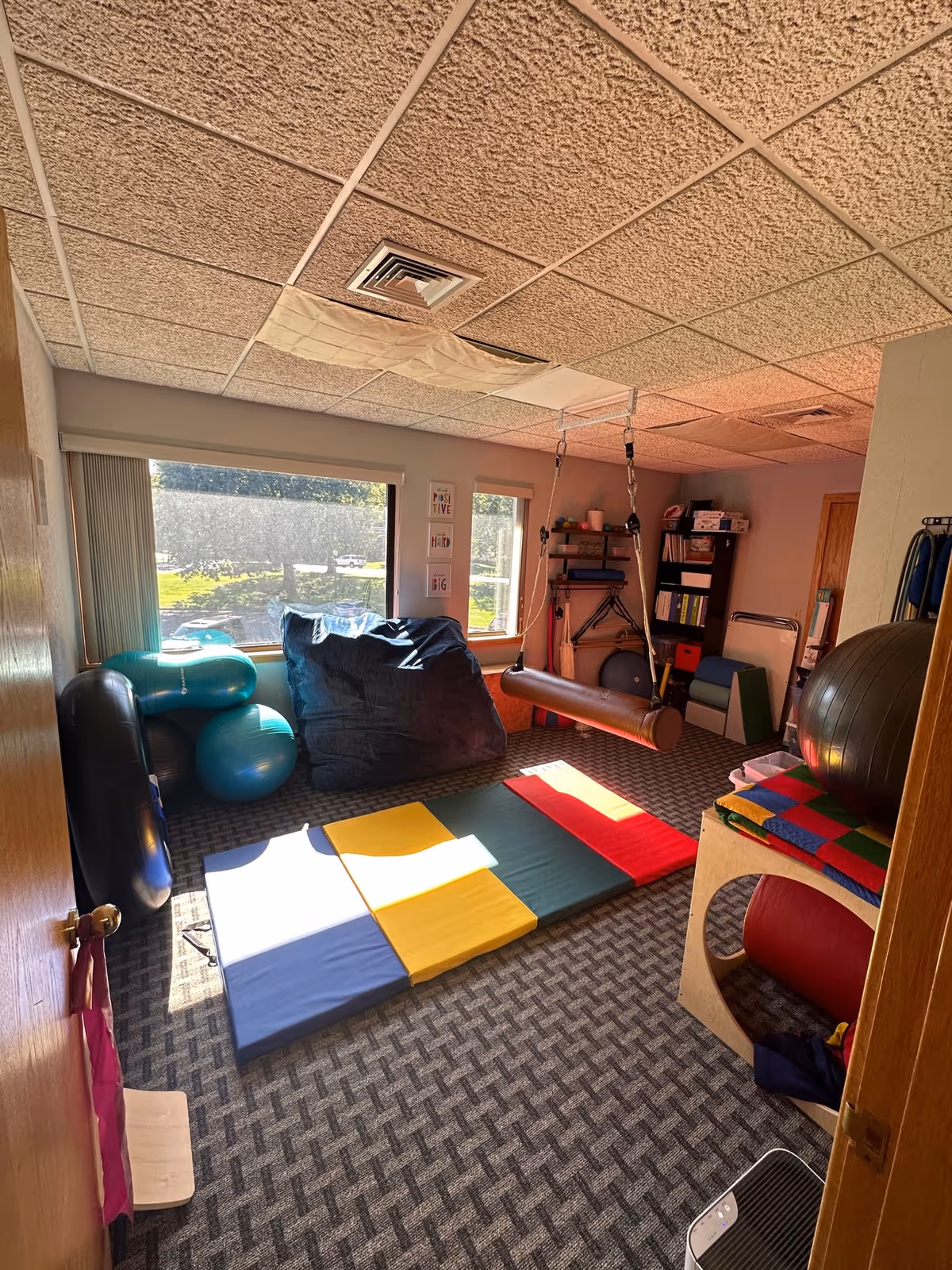A therapy room with colorful mats, exercise balls, and equipment in Mindful Motion Therapy LLC.