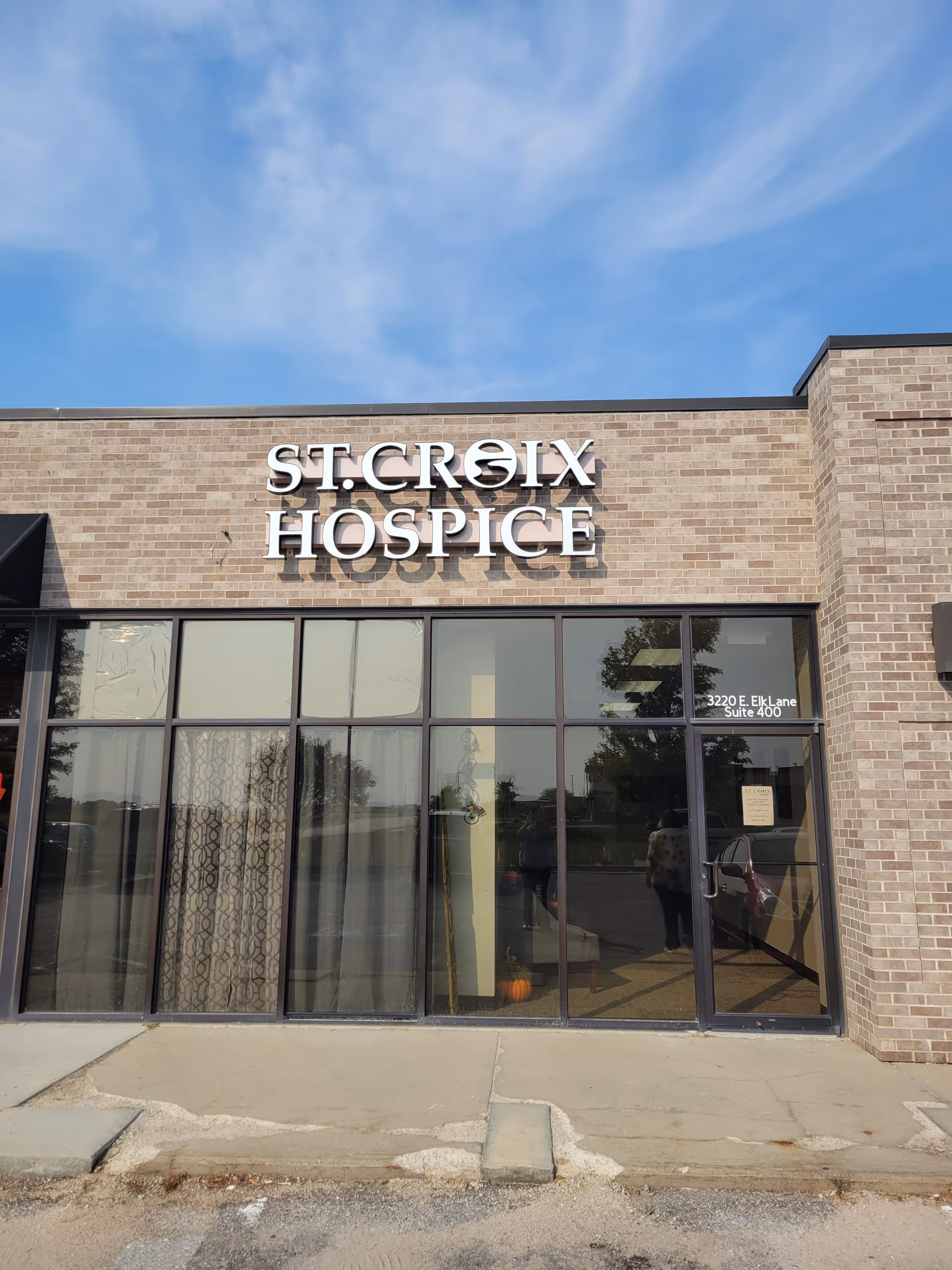 Front view of St. Croix Hospice building with brick facade and large glass windows.