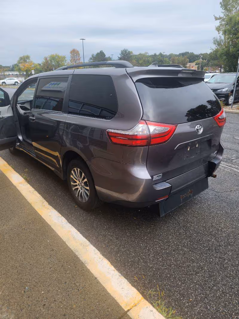 Gray MobilityWorks van with open passenger door parked in a lot.