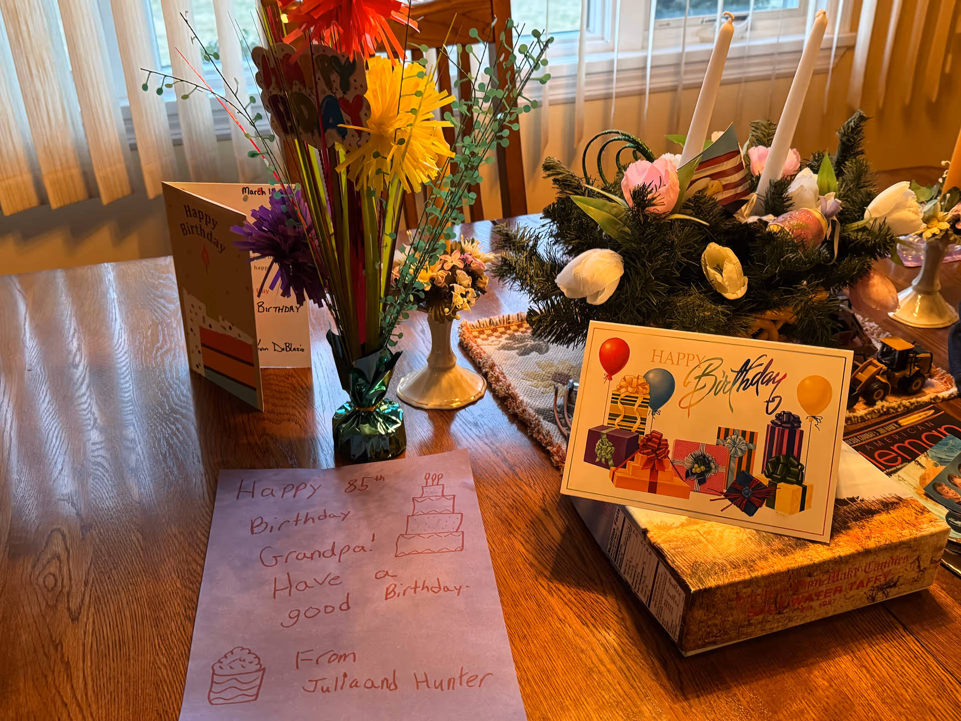 Birthday decorations and cards on a wooden table at Right at Home senior living facility.