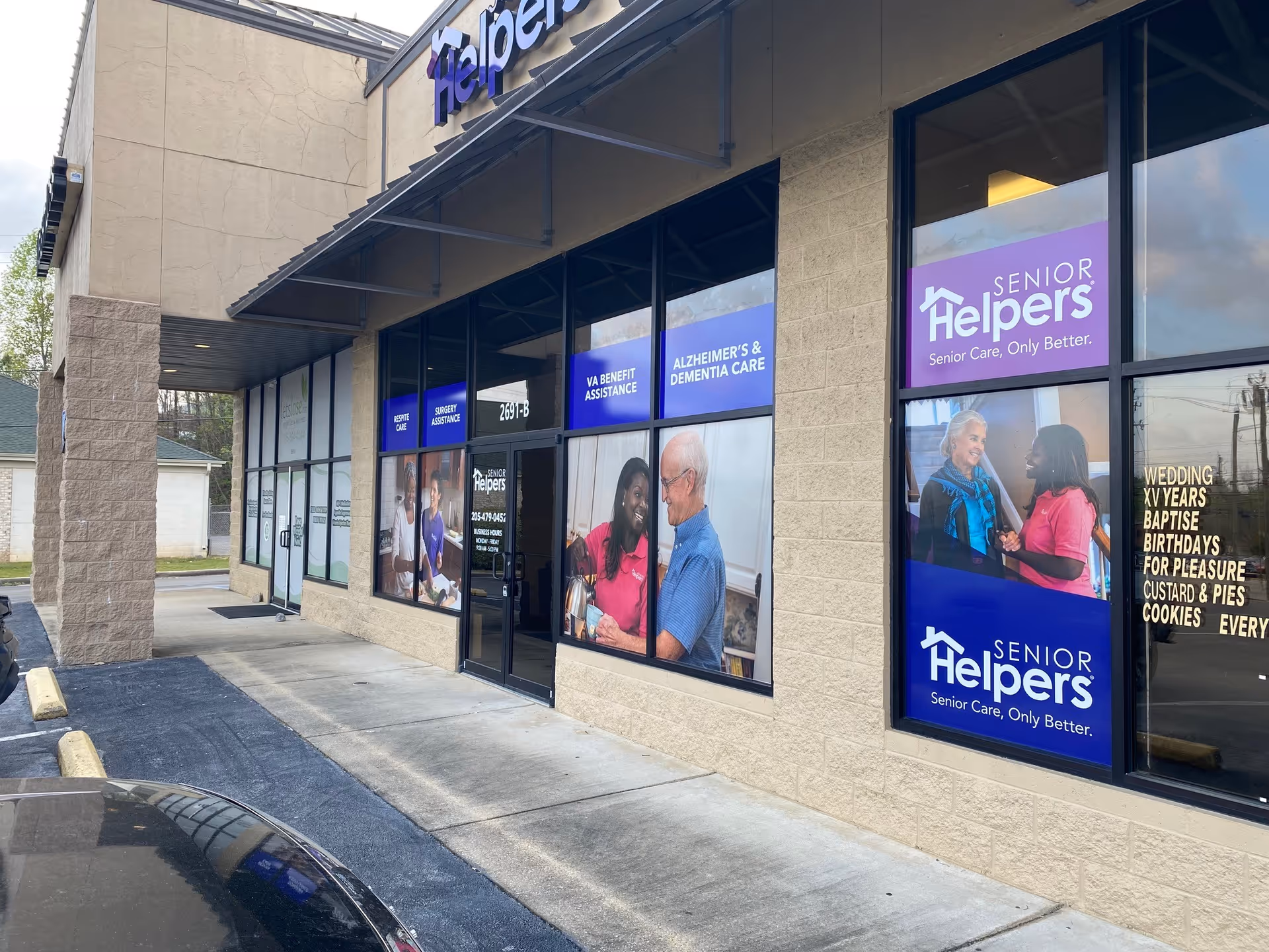 Exterior view of a Senior Helpers storefront with large windows and promotional signs.