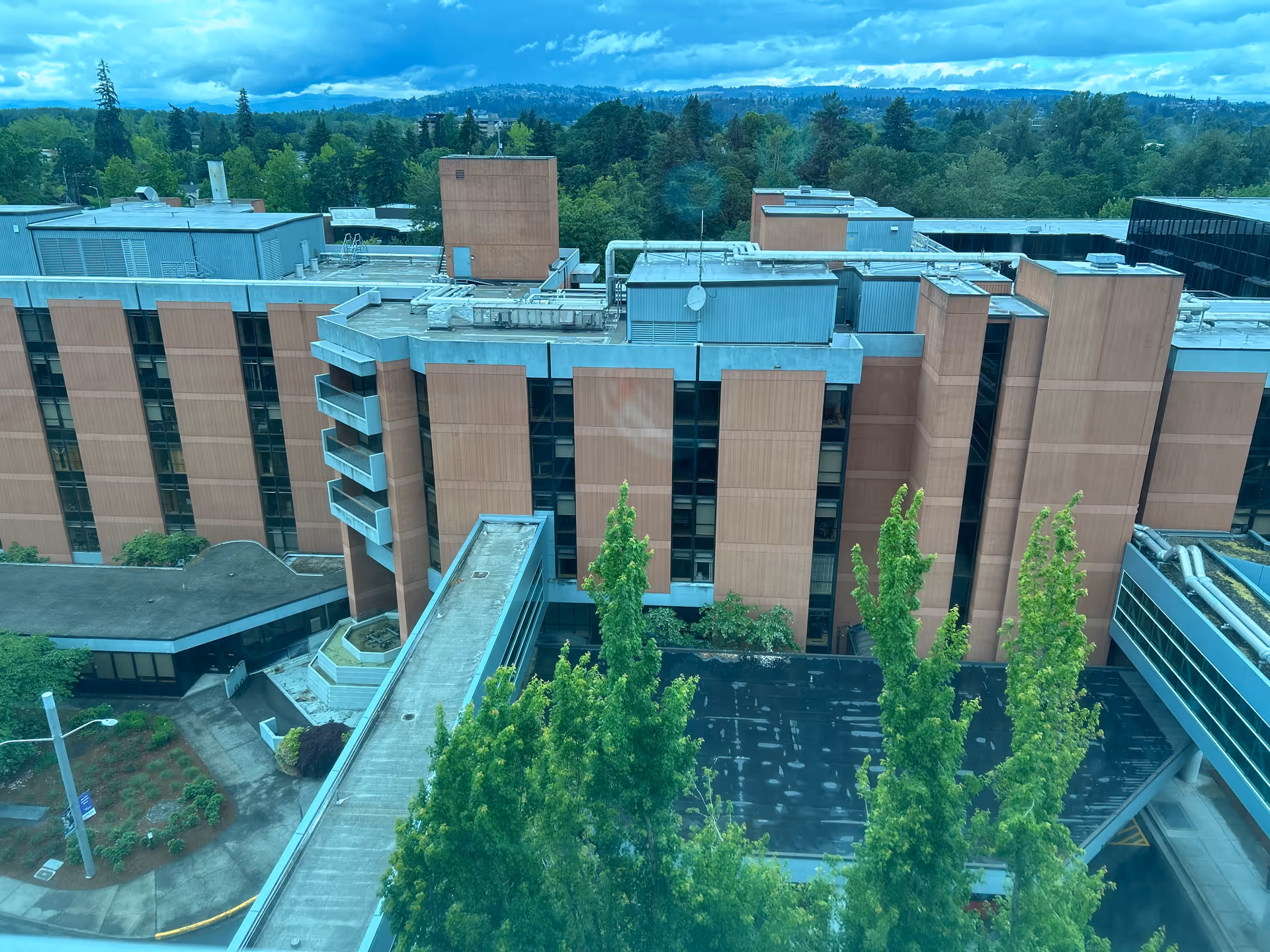 Aerial view of Salem Health Emergency Department building with brown brick exterior and surrounding trees.