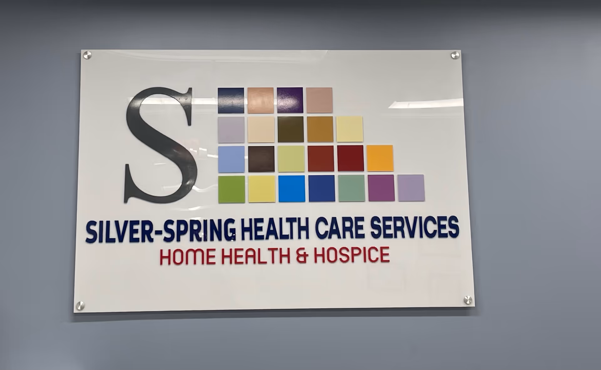 Sign reading Silver-Spring Health Care Services and Home Health & Hospice mounted on wall.