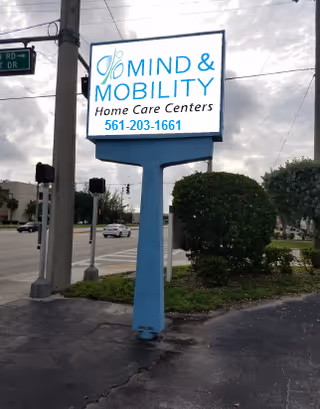 Outdoor street sign for Mind & Mobility Home Care Centers in a parking lot.