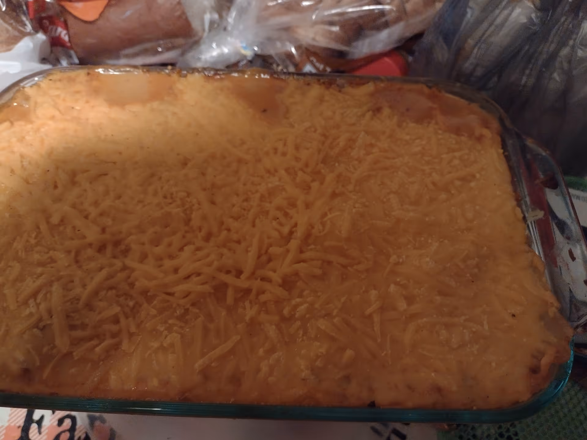 Cheesy baked casserole in a glass dish on a kitchen counter.