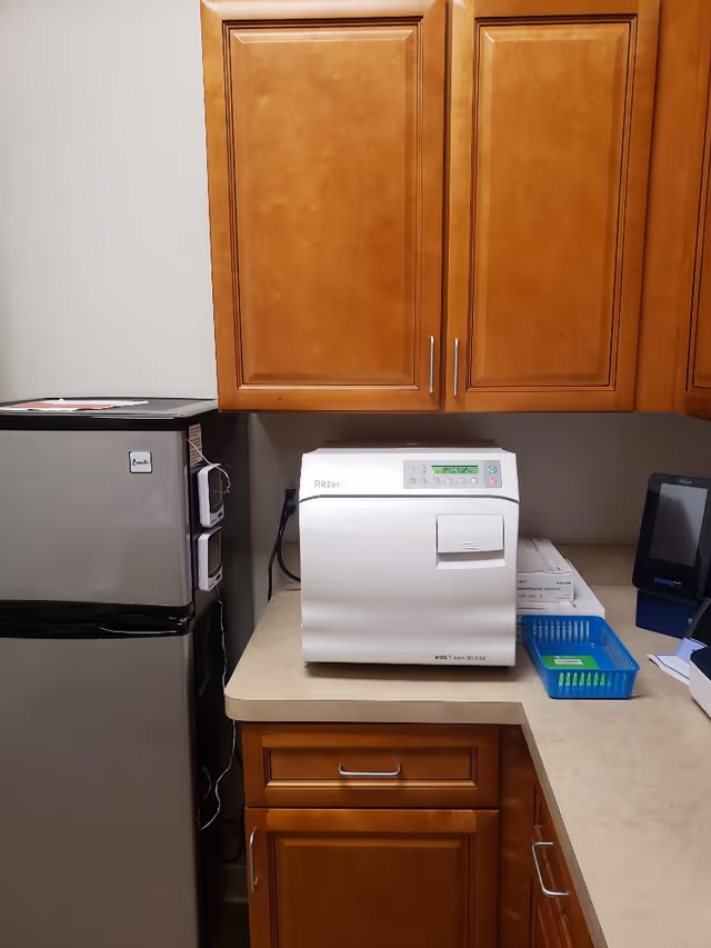Wooden cabinets above a counter with a refrigerator and a white kitchen appliance.