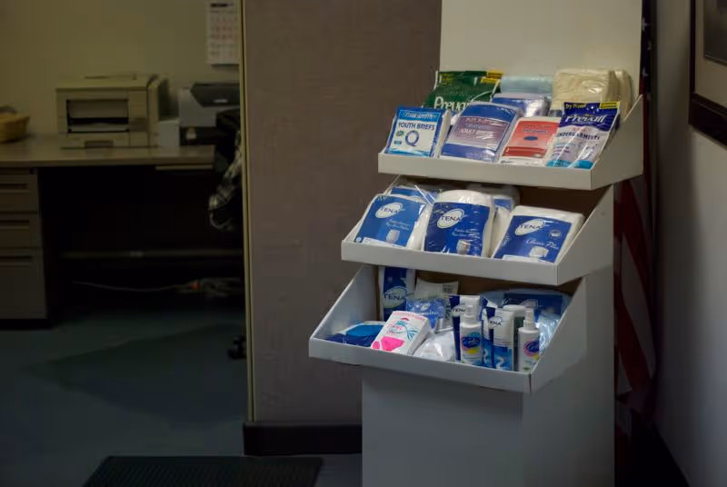 Display shelf with assorted diaper and incontinence products in a small supply area.