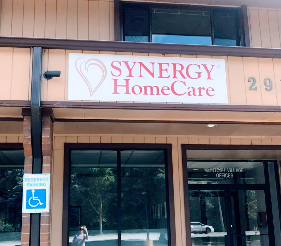 Front view of a SYNERGY HomeCare building with signage and a handicapped parking sign.