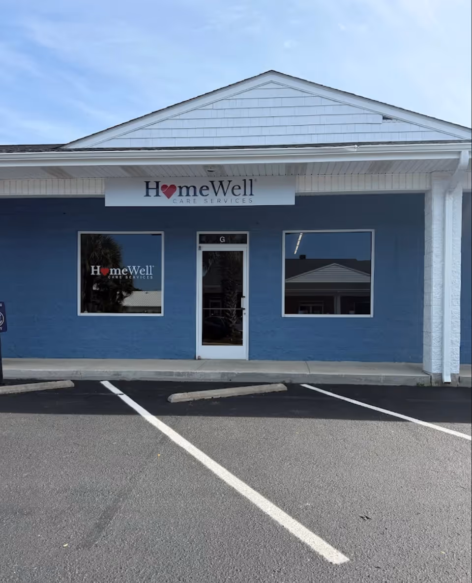 Blue exterior of HomeWell Care Services storefront with sign above door.