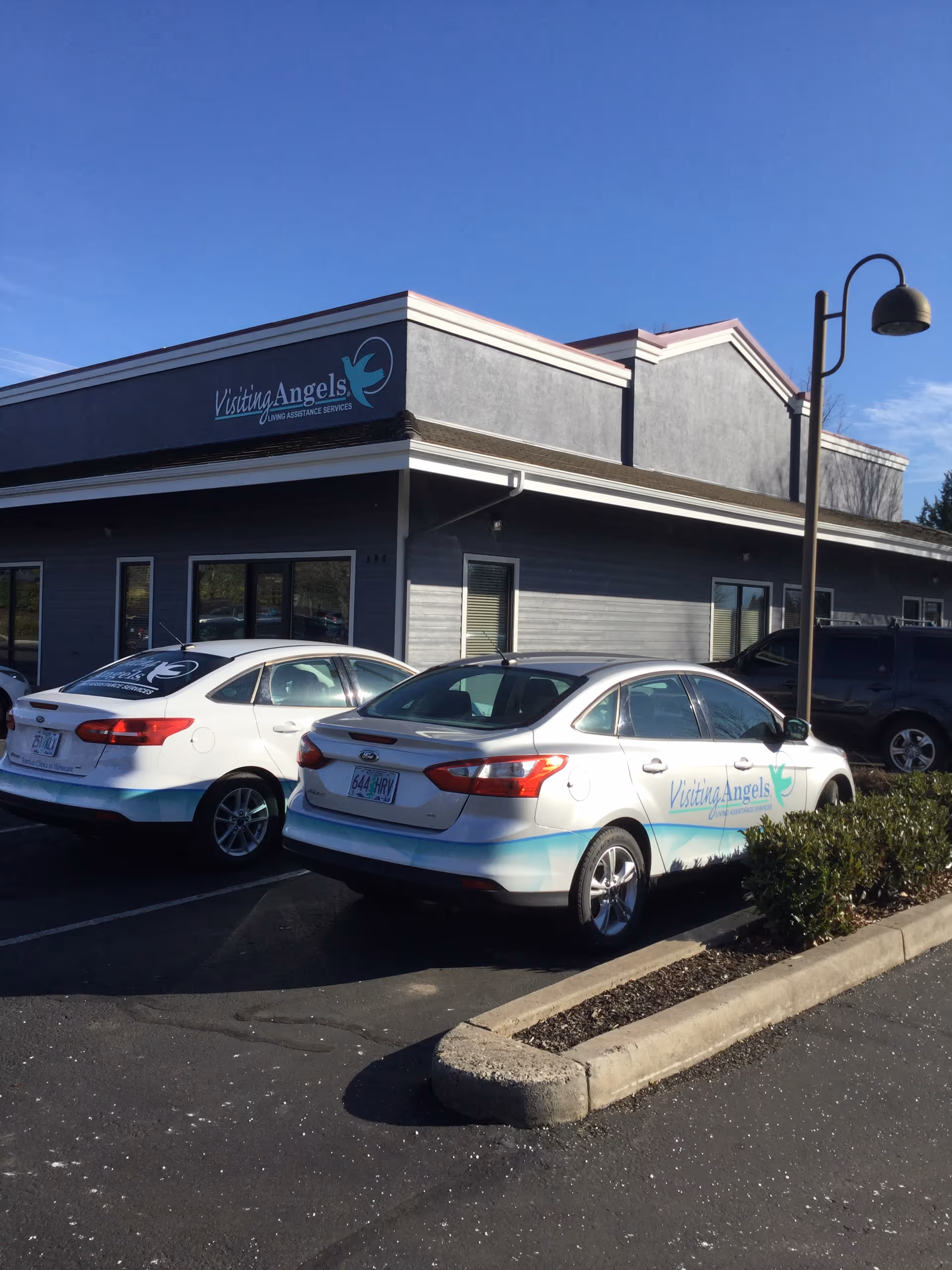 Exterior view of Visiting Angels building with parked cars in front of the facility.