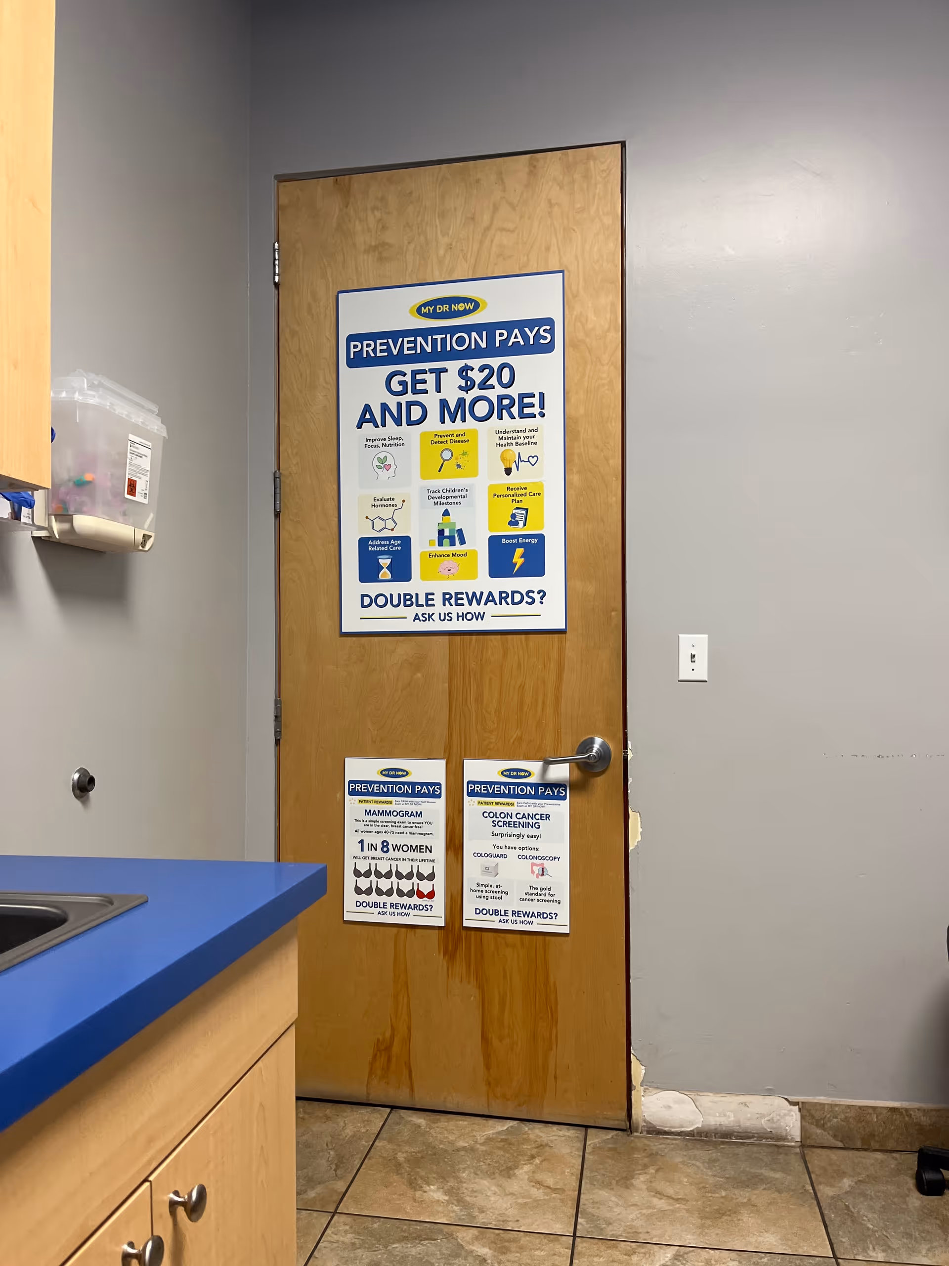 Interior wooden door covered in health posters in a facility kitchenette.