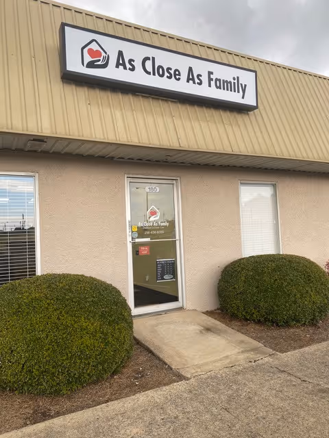 Exterior view of the facility entrance with a sign reading 'As Close As Family'.