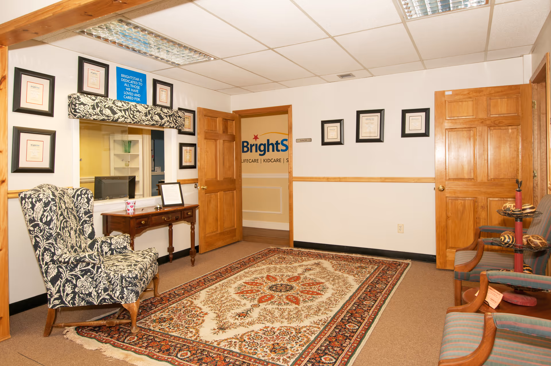 BrightStar Care lobby interior with chairs, rug, framed certificates, and a reception desk.