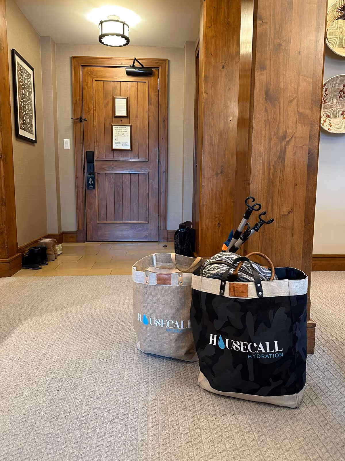 Interior hallway featuring a wooden door and two House Call Hydration bags.