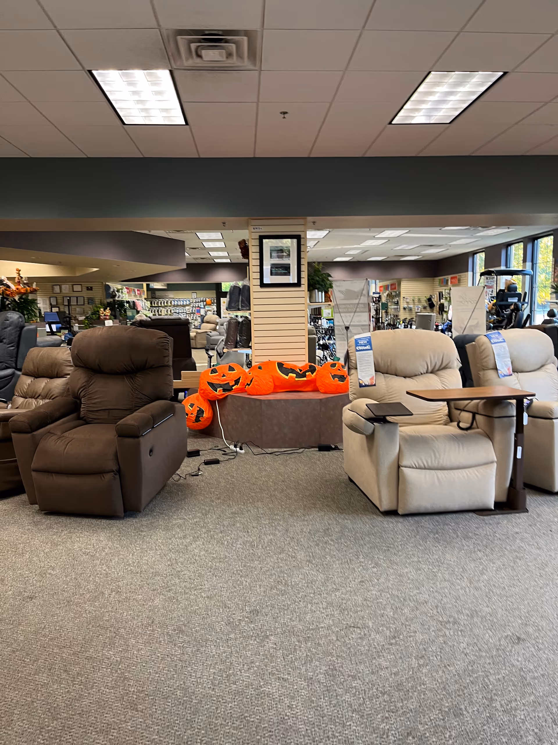 Indoor furniture showroom at Alick's Home Medical with recliners and Halloween pumpkins.