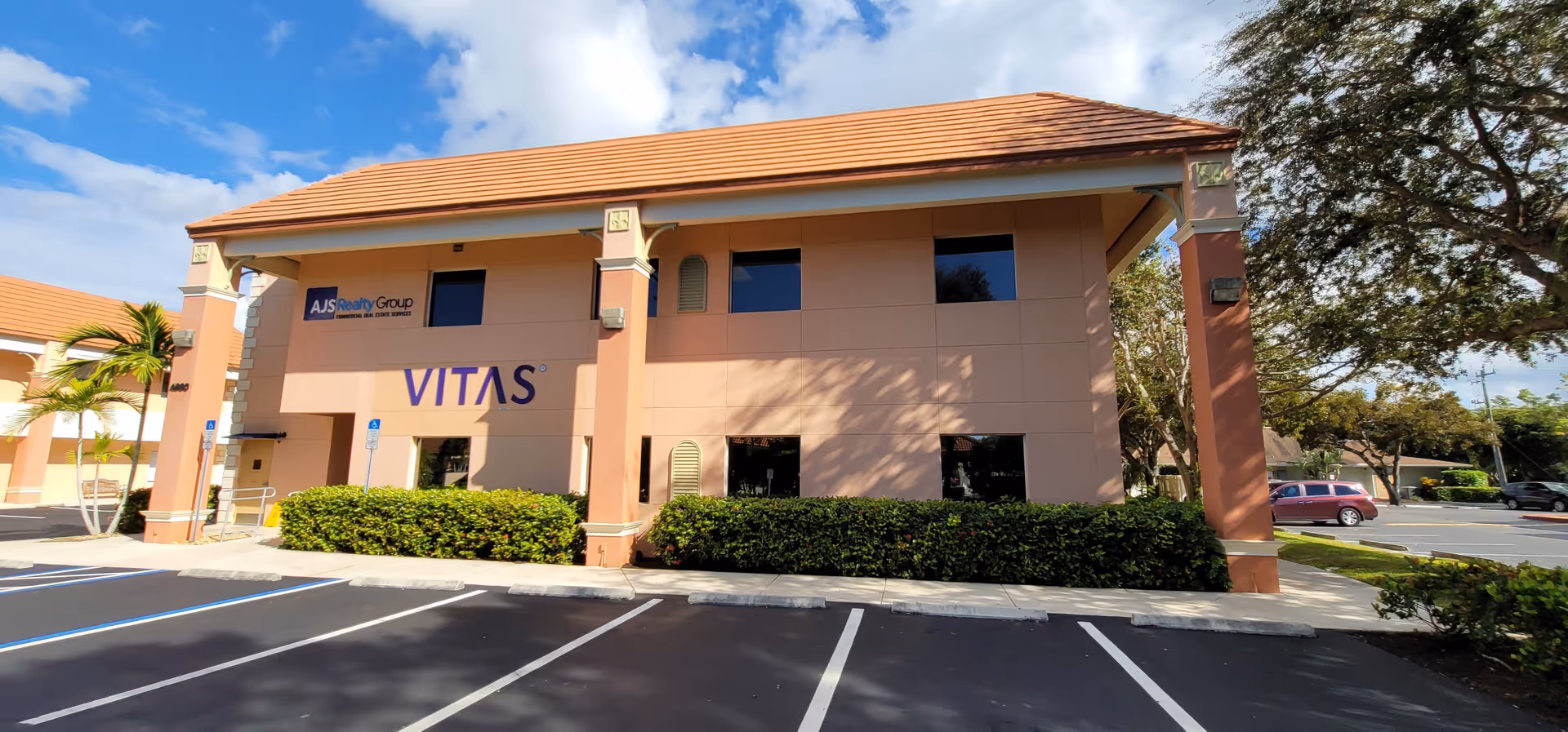 Exterior view of a VITAS Healthcare building with parking and signage.